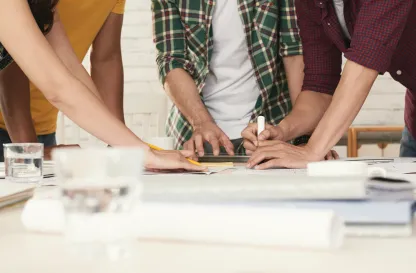 Aktualności | Uniwersytet Dolnośląski DSW we Wrocławiu: Grupa osób pracuje wspólnie przy jednym stole