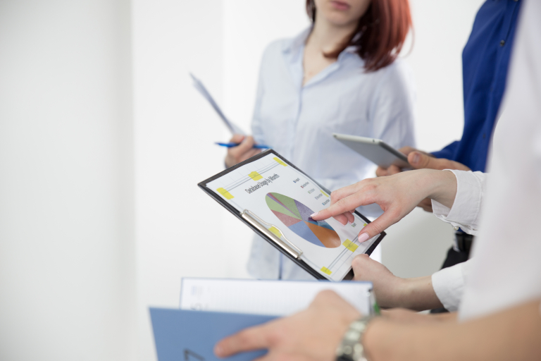 Organizacja i zarządzanie oświatą | Studia podyplomowe we Wrocławiu | Uniwersytet Dolnośląski DSW we Wrocławiu: Grupa osób omawia wspólnie wykres kołowy