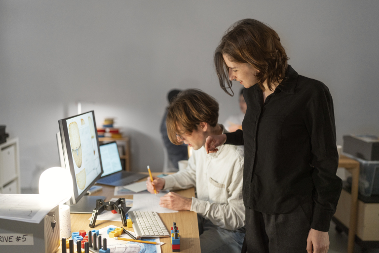 Resocjalizacja | Studia podyplomowe we Wrocławiu | Uniwersytet Dolnośląski DSW we Wrocławiu: Dwie osoby pracują przy projektcie przed komputerem