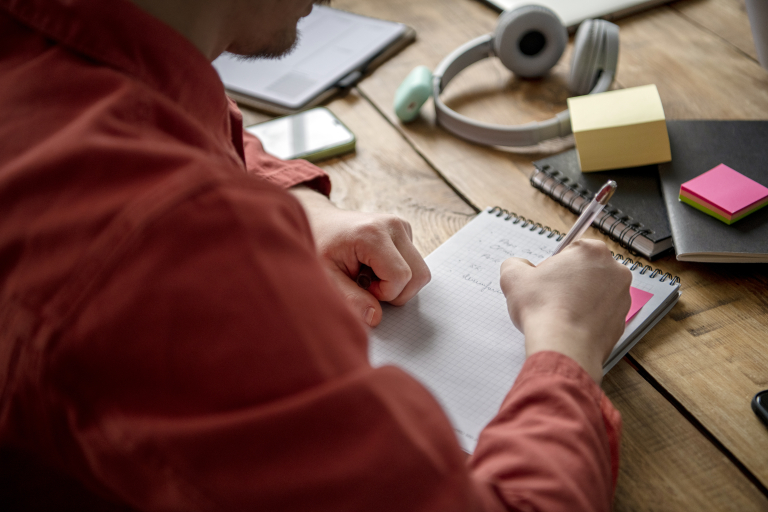 Socjoterapia | Studia podyplomowe we Wrocławiu | Uniwersytet Dolnośląski DSW we Wrocławiu: Mężczyzna piszący w notesie