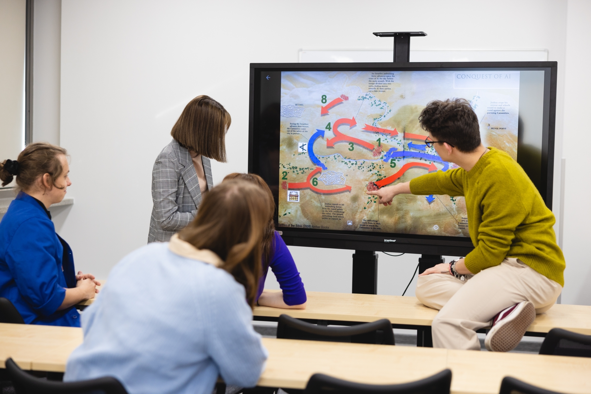 Grupa osób spoglądająca na telewizor