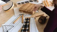Integracja sensoryczna i psychomotoryka | Uniwersytet Dolnośląski DSW we Wrocławiu: instrumenty leżące na stole: cymbałki, trójkąt, tamburyno