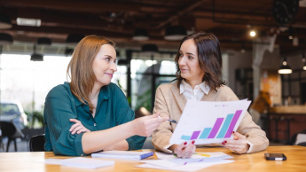 ESG - menedżer ds. zrównoważonego rozwoju | Studia podyplomowe we Wrocławiu | Uniwersytet Dolnośląski DSW we Wrocławiu: Główna grafika: Szkolenia i kursy - dwie studentki oglądające dane wizualne