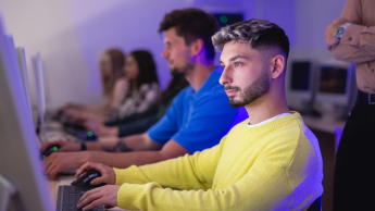 Nowoczesne technologie cyfrowe w edukacji (EdTech) | Studia podyplomowe we Wrocławiu | Uniwersytet Dolnośląski DSW we Wrocławiu: Główna grafika: Inżynier aplikacji i systemów chmurowych  - student w żółtym swetrze robiący zadanie przy komputerze