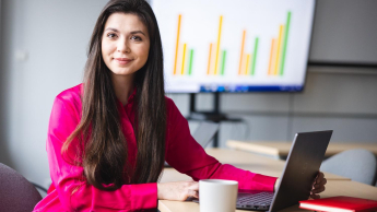 Marketing i social media w biznesie | Studia I stopnia we Wrocławiu | Uniwersytet Dolnośląski DSW we Wrocławiu: Studentka w różowej koszuli siedząca przy komputerze i kubku kawy