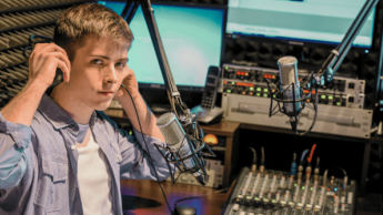 Produkcja muzyczna | Studia podyplomowe we Wrocławiu | Uniwersytet Dolnośląski DSW we Wrocławiu: student przy mikrofonie