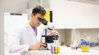 Psychodietetyka z obesitologią | Studia I stopnia we Wrocławiu | Uniwersytet Dolnośląski DSW we Wrocławiu: student pracujący z mikroskopem