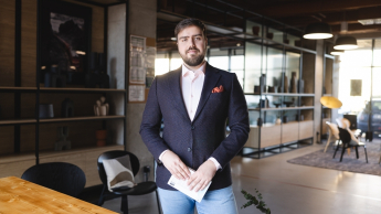 Akademia doradców sprzedaży | Studia podyplomowe we Wrocławiu | Uniwersytet Dolnośląski DSW we Wrocławiu: student w czarnej marynarce, trzyma notatki w ręku