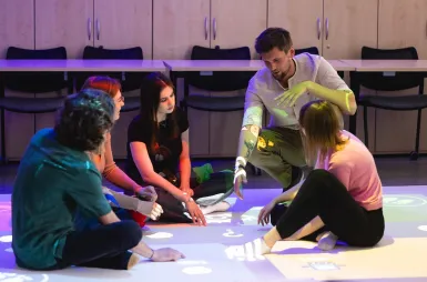 Nasz kampus | Uniwersytet Dolnośląski DSW we Wrocławiu: Prowadzący tłumaczy ćwiczenie studentom 