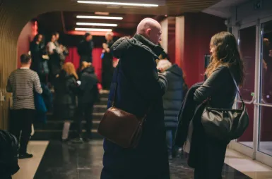 Studencki Dyskusyjny Klub Filmowy UDDSW zaprasza na kolejny film | 03.03.2026 | Aktualności | Uniwersytet Dolnośląski DSW we Wrocławiu: ludzie rozmawiający ze sobą na korytarzu