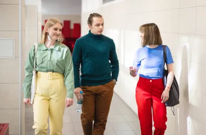 Poradniki - dzielimy się wiedzą | Uniwersytet Dolnośląski DSW we Wrocławiu: Grupa osób idąca w korytarzu