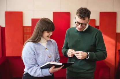 Podcasty | Uniwersytet Dolnośląski DSW we Wrocławiu: Dwie osoby spoglądające na książkę