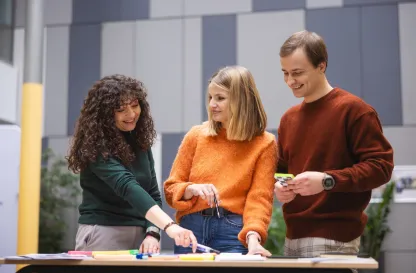 Poradniki - dzielimy się wiedzą | Uniwersytet Dolnośląski DSW we Wrocławiu: Grupa osób stojąca przy stole