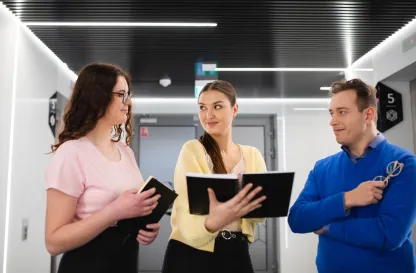 Poradniki - dzielimy się wiedzą | Uniwersytet Dolnośląski DSW we Wrocławiu: Grupa osób stojąca w korytarzu