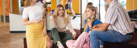 Dział Współpracy Międzynarodowej i Welcome Center | Uniwersytet Dolnośląski DSW we Wrocławiu: Główna grafika: Dział Współpracy z Zagranicą - grupa studentów rozmawiająca na pufach