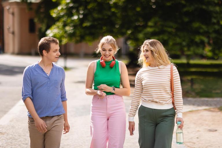 Rankingi i akredytacje | Uniwersytet Dolnośląski DSW we Wrocławiu: Główna grafika: Stypendia i zniżki - trzy osoby spacerujące po Wrocławiu