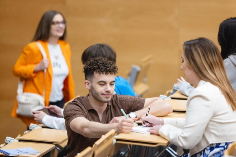 Maturzyści | Uniwersytet Dolnośląski DSW we Wrocławiu: Główna grafika: Maturzyści - studenci siedzący razem na auli