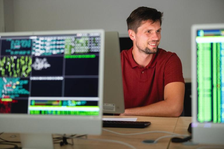 Informatyka w przemyśle 4.0 | Studia I stopnia we Wrocławiu | Uniwersytet Dolnośląski DSW we Wrocławiu: Główna grafika: student siedzący przy komputerach