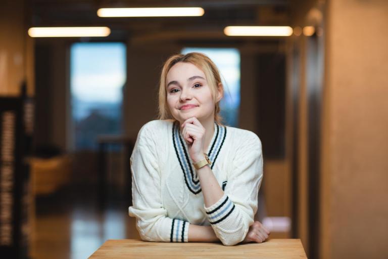 Logistyka przedsiębiorstwa z elementami ESG | Studia I stopnia we Wrocławiu | Uniwersytet Dolnośląski DSW we Wrocławiu: Grafika główna - studentka w białym sweterku