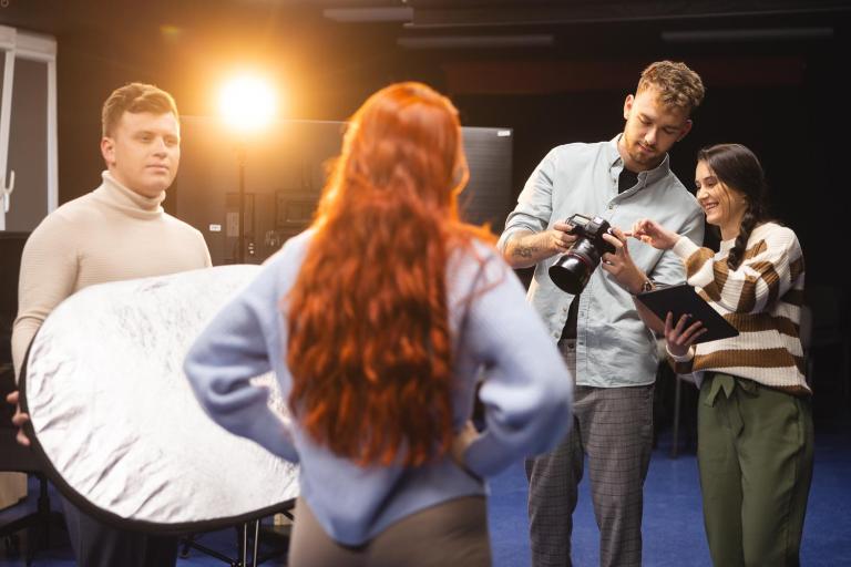 Influencing i kreowanie wizerunku w social mediach | Studia I stopnia we Wrocławiu | Uniwersytet Dolnośląski DSW we Wrocławiu: Studenci oglądający zrobione zdjęcie studentki