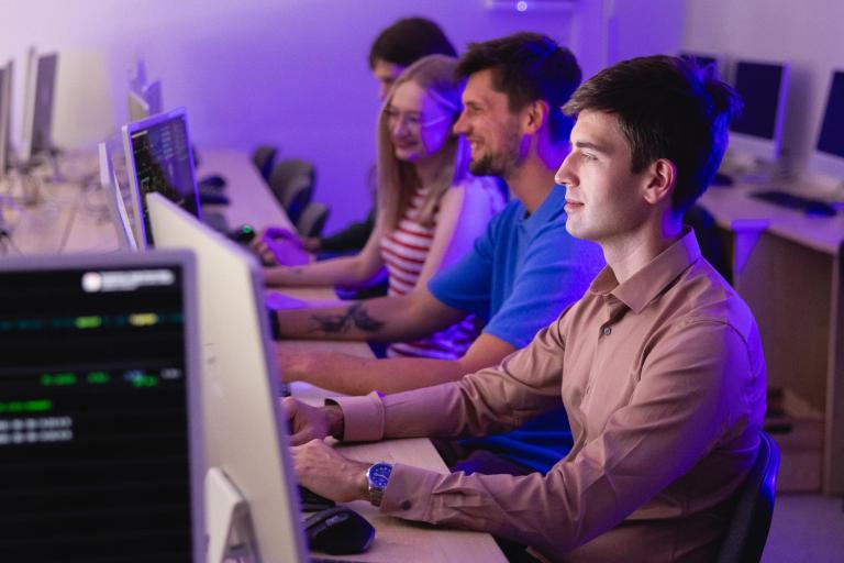 Informatyka | Studia I stopnia we Wrocławiu | Uniwersytet Dolnośląski DSW we Wrocławiu: Zajęcia z informatyki - 4 studentów przy komputerach