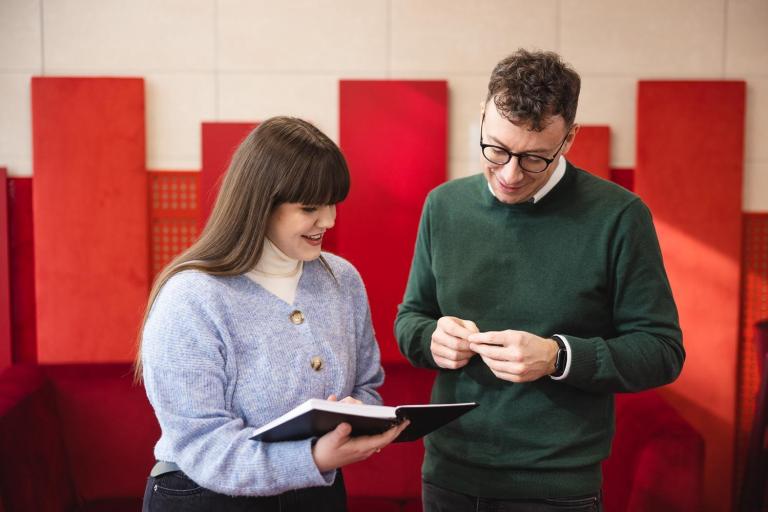 Content i influencer marketing | Studia I stopnia we Wrocławiu | Uniwersytet Dolnośląski DSW we Wrocławiu: Studentka z wykładowcą oglądają wykonane notatki