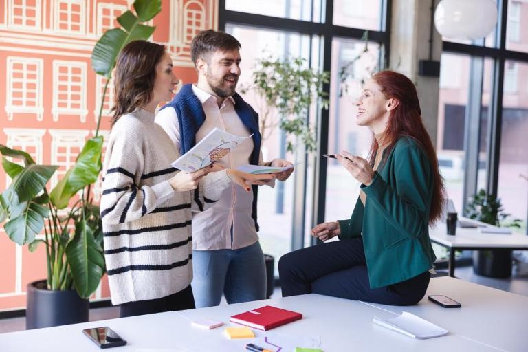 Marketing i social media w biznesie | Studia I stopnia we Wrocławiu | Uniwersytet Dolnośląski DSW we Wrocławiu: Rozmowa trzech studentów przy biurku