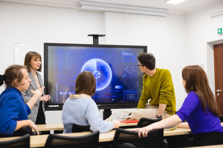 Ochrona ludności i przeciwdziałanie konfliktom hybrydowym | Studia I stopnia we Wrocławiu | Uniwersytet Dolnośląski DSW we Wrocławiu: zajęcia z bezpieczeństwa narodowego, studenci wspólnie oglądają prezentację