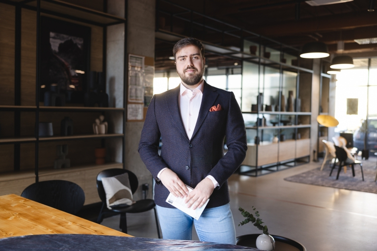 Projekty i usługi | Uniwersytet Dolnośląski DSW we Wrocławiu: student w czarnej marynarce, trzyma notatki w ręku