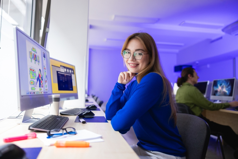 Psychologia komunikacji online i social mediów | Studia I stopnia we Wrocławiu | Uniwersytet Dolnośląski DSW we Wrocławiu: studentka w niebieskiej koszulce siedząca w sali od informatyki