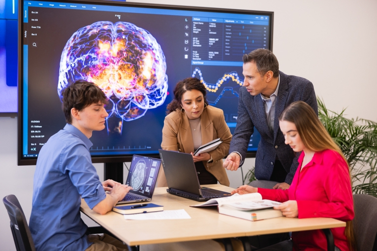 Psychologia w UX & behavioral design | Studia I stopnia we Wrocławiu | Uniwersytet Dolnośląski DSW we Wrocławiu: studenci z wykładowcą podczas zajęć z psychologii i informatyki