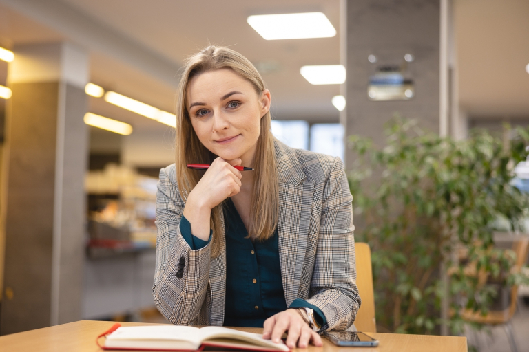 Zarządzanie w administracji publicznej | Studia I stopnia we Wrocławiu | Uniwersytet Dolnośląski DSW we Wrocławiu: studentka siedząca przy notatniku