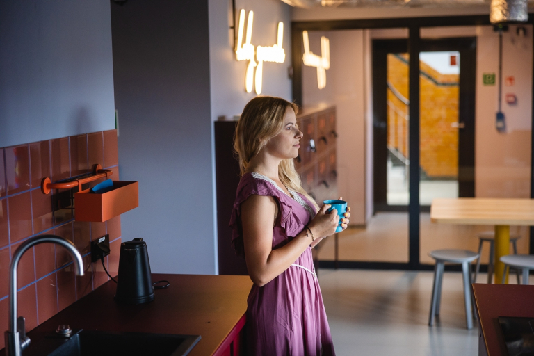 Pedagogika opiekuńczo-wychowawcza z elementami wielokulturowości | Studia I stopnia we Wrocławiu | Uniwersytet Dolnośląski DSW we Wrocławiu: studentka w fioletowej sukience trzymająca turkusowy kubek