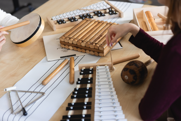 Arteterapia | Studia podyplomowe we Wrocławiu | Uniwersytet Dolnośląski DSW we Wrocławiu: instrumenty leżące na stole: cymbałki, trójkąt, tamburyno