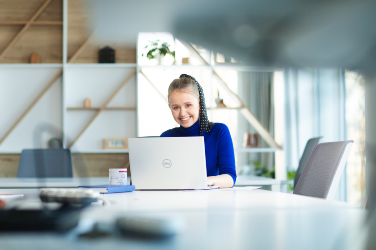 First Time Manager | Studia podyplomowe we Wrocławiu | Uniwersytet Dolnośląski DSW we Wrocławiu: Strona główna: Akademia zarządzania zmianą i strategią studia podyplomowe, Wrocław: studentka w granatowym swetrze siedząca przy komputerze