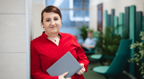 O edukacji z praktykami | Uniwersytet Dolnośląski DSW we Wrocławiu: dr Barbara Pawełko-Czajka w czerwonej koszuli trzymająca tablet