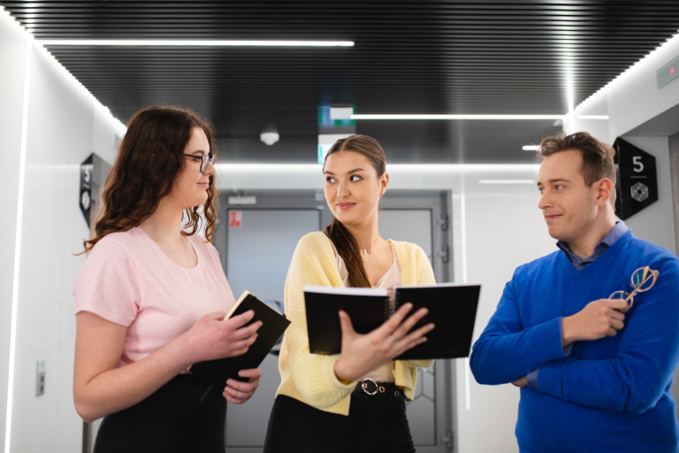 Doradca w procesie sukcesji | Studia podyplomowe we Wrocławiu | Uniwersytet Dolnośląski DSW we Wrocławiu: Grupa osób stojąca w korytarzu