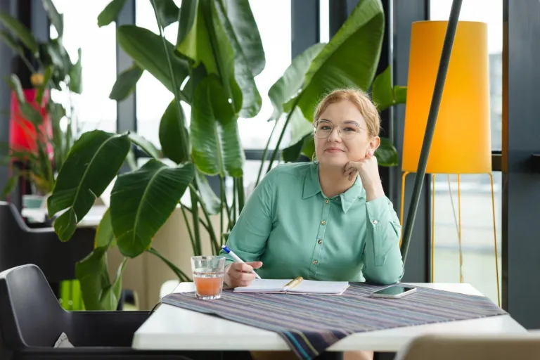 Maturzyści | Uniwersytet Dolnośląski DSW we Wrocławiu: Główna grafika: Maturzyści - Studentka siedząca przy stole