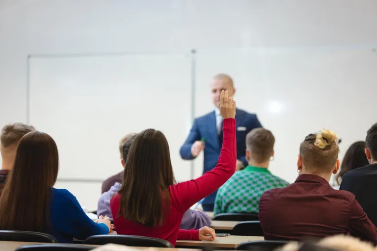 Integrating Language, Literacy and Subject Teaching in Plurilingual and Pluricultural Education Contexts (ILLS-PEC) | Uniwersytet Dolnośląski DSW we Wrocławiu: Główna grafika: Studentka w różowej koszulce zgłaszająca się na zajęciach