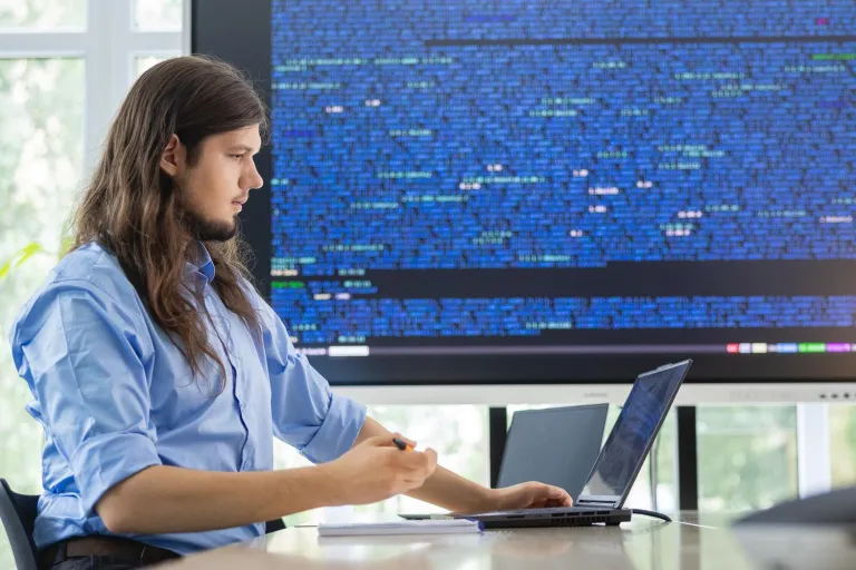 Nagrody naukowe | Uniwersytet Dolnośląski DSW we Wrocławiu: Grafika główna: Informatyka w przemyśle 4.0 - student pracujący nad zagadnieniami z informatyki