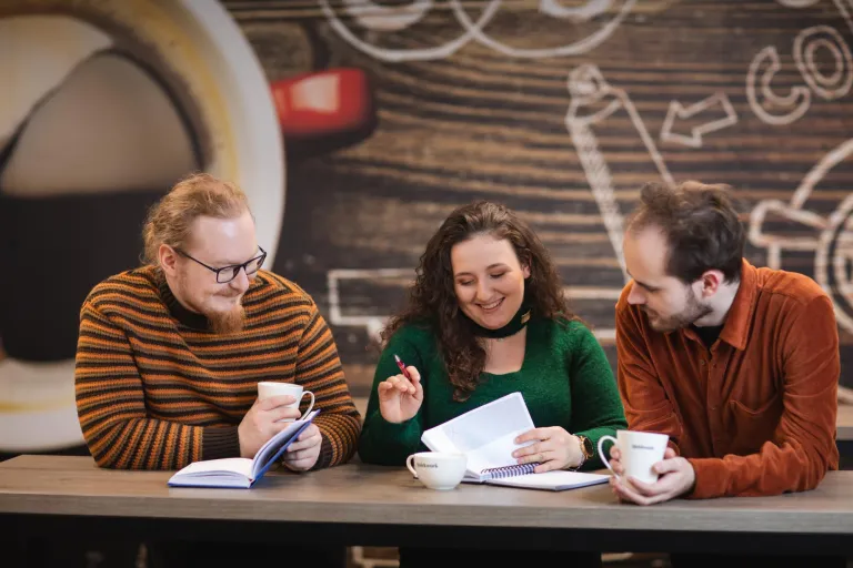 Analityka i optymalizacja finansowa | Studia I stopnia we Wrocławiu | Uniwersytet Dolnośląski DSW we Wrocławiu: trójka studentów, wspólnie ucząca się w kawiarni