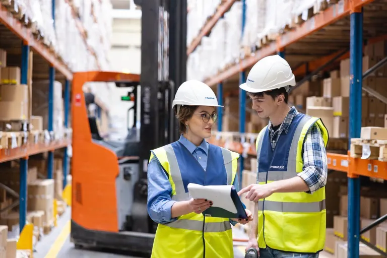 Logistyka produkcji i automatyzacja procesów | Studia I stopnia we Wrocławiu | Uniwersytet Dolnośląski DSW we Wrocławiu: Studenci logistyki w kamizelkach odblaskowych i kaskach, w magazynie