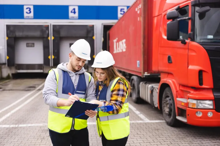 Logistyka przedsiębiorstwa z elementami ESG | Studia I stopnia we Wrocławiu | Uniwersytet Dolnośląski DSW we Wrocławiu: Studenci logistyki w kamizelkach odblaskowych i kaskach