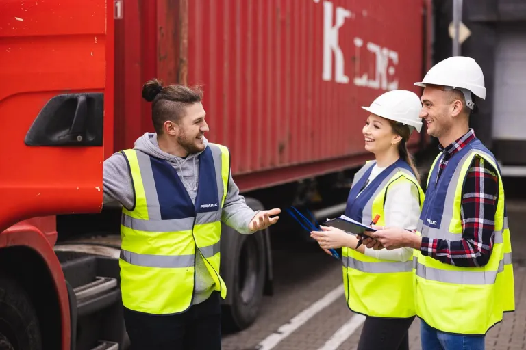 Logistyka transportu i spedycji | Studia I stopnia we Wrocławiu | Uniwersytet Dolnośląski DSW we Wrocławiu: Studenci logistyki przy czerwonej ciężarówce