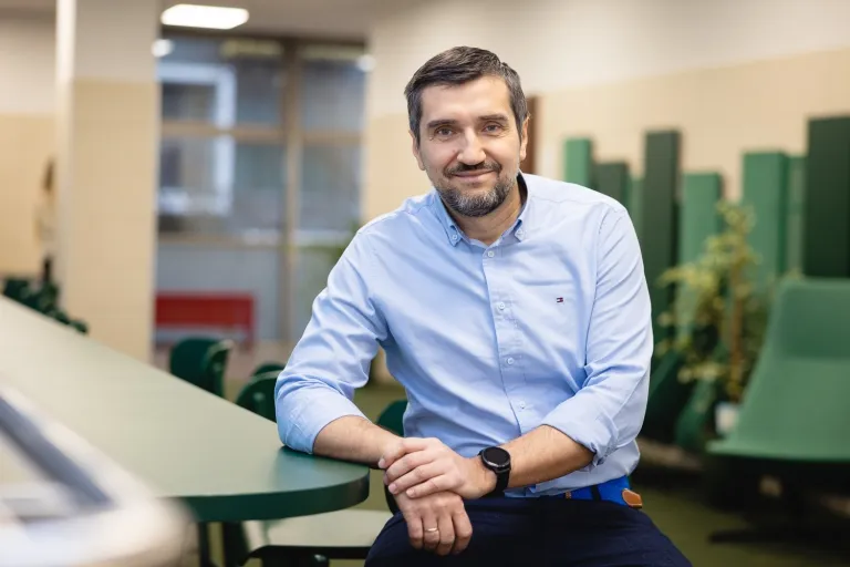 Human resources i coaching | Studia II stopnia we Wrocławiu | Uniwersytet Dolnośląski DSW we Wrocławiu: mężczyzna w niebieskiej koszuli siedzący przy zielonym stoliku