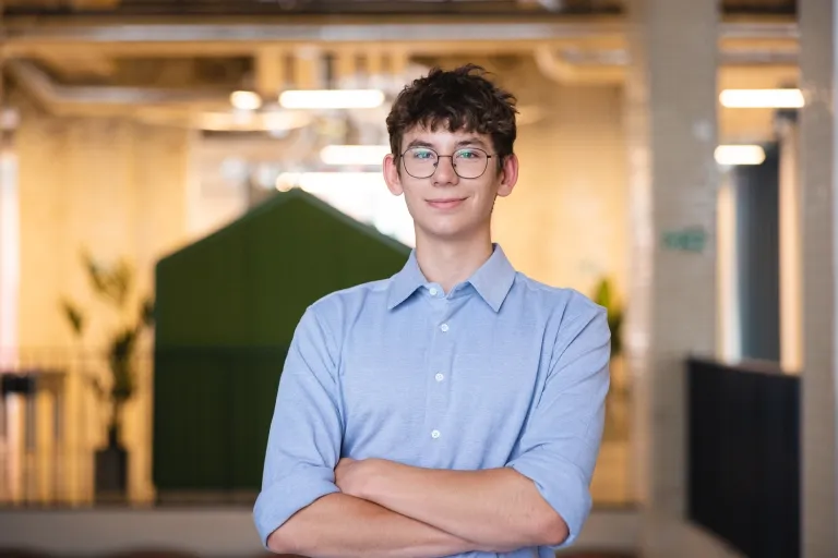 Wrocław pomaga. Fenomen polskiej pomocy, solidarności i braterstwa. | Blog "okiem praktyków" | Uniwersytet Dolnośląski DSW we Wrocławiu: student w niebieskiej koszuli i okularach