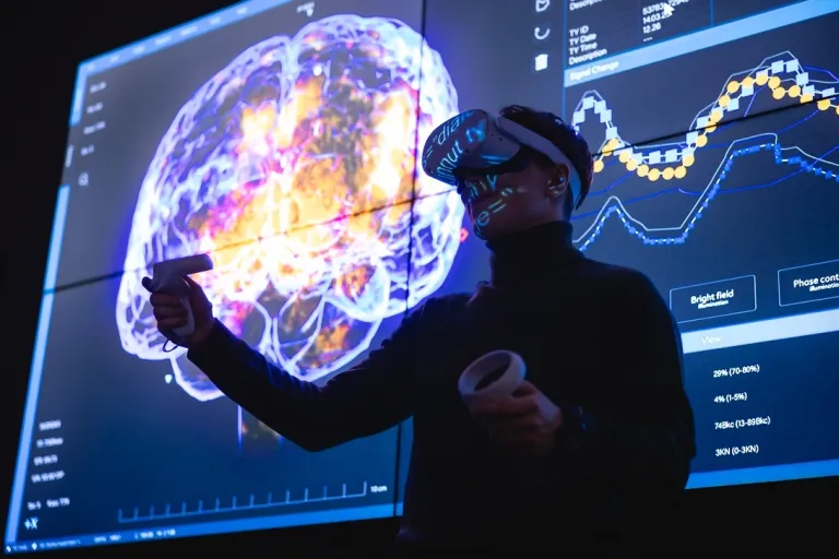 Psychologia i informatyka | Studia II stopnia we Wrocławiu | Uniwersytet Dolnośląski DSW we Wrocławiu: Student w okularach VR, w tle widnieje wizualizacja ludzkiego mózgu