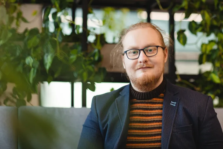 Druk 3D w przemyśle | Studia I stopnia we Wrocławiu | Uniwersytet Dolnośląski DSW we Wrocławiu: student w koszulce w czarno-pomarańczowe paski i czarnej marynarce