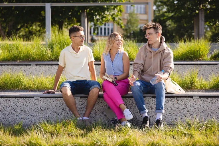 Kreowanie i realizacja kampanii wizerunkowych | Studia I stopnia we Wrocławiu | Uniwersytet Dolnośląski DSW we Wrocławiu: trójka studentów siedząca na schodach na dworze