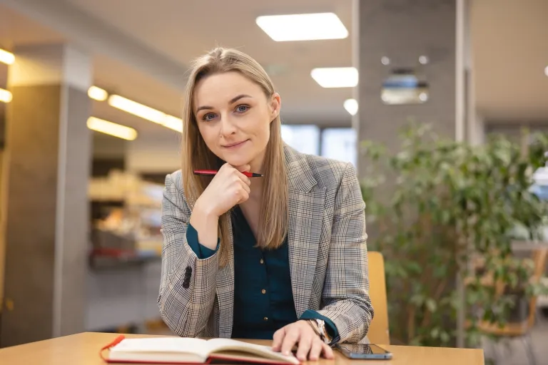 Compliance z elementami ESG | Studia I stopnia we Wrocławiu | Uniwersytet Dolnośląski DSW we Wrocławiu: studentka siedząca przy notatniku